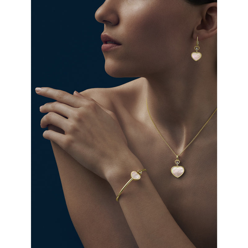 Model wearing Happy Hearts Yellow Gold Mother of Pearl Bangle, earrings and pendant